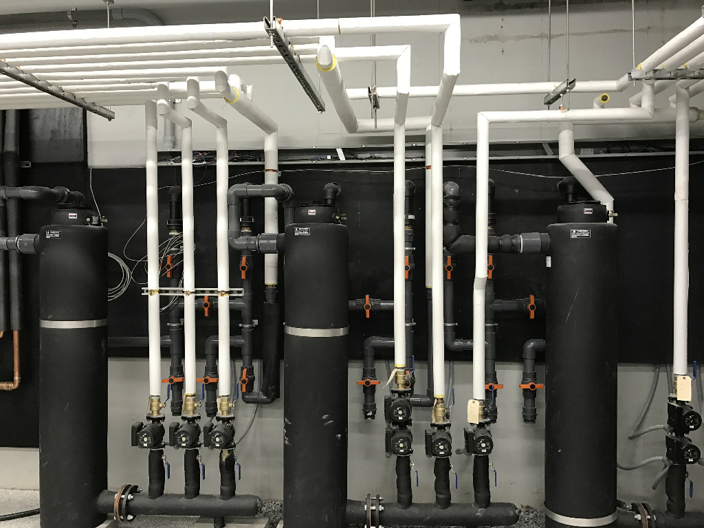 A Black Color Cylinders Wall With Connected Pipes